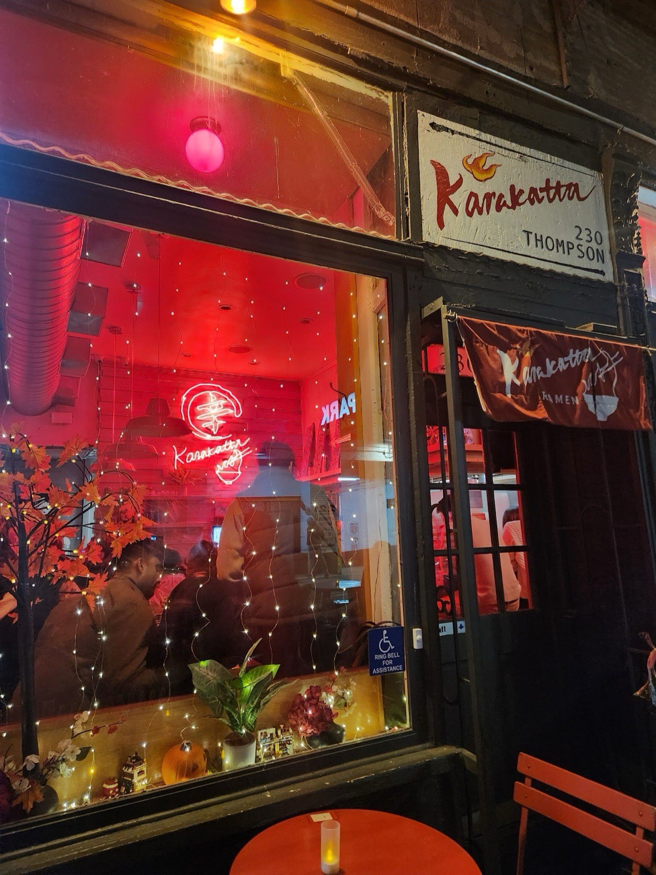 Karakatta Ramen storefront at 230 Thompson Street, Greenwich Village, with warm red lighting and traditional Japanese noren curtain